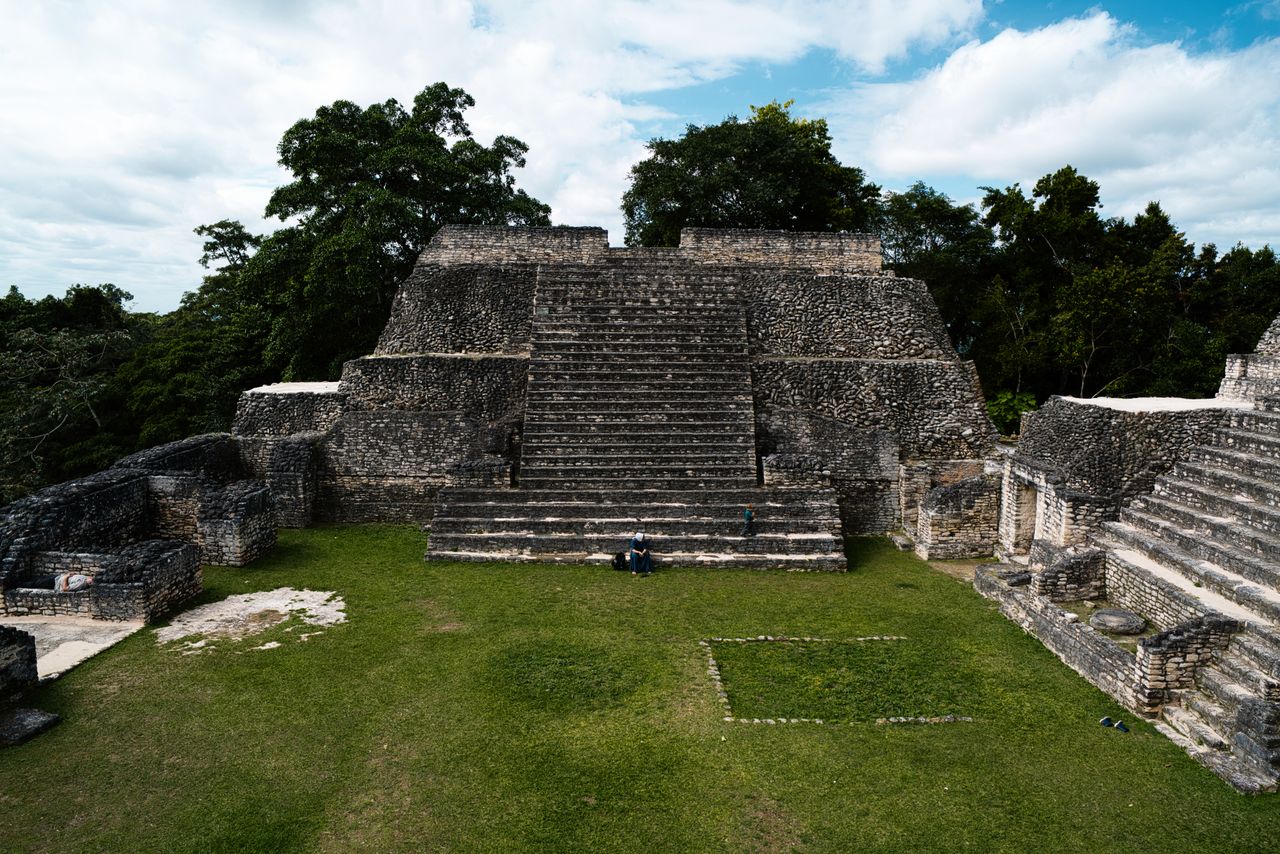 Explore the ancient Mayan pyramid surrounded by lush jungle and stone steps in Guatemala.