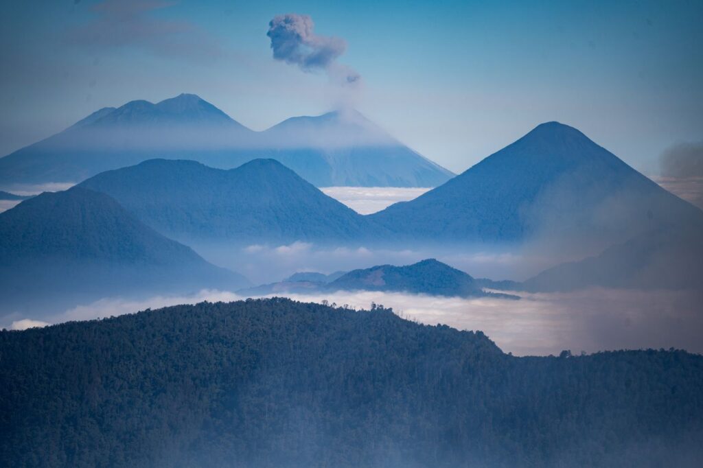 pexels-photo-23876565-2 A scenic view of volcanoes under cloud-filled skies, showcasing nature's raw beauty.