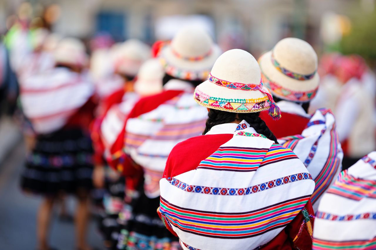 Colorful parade in Cusco, Peru with dancers in traditional costumes, celebrating heritage.