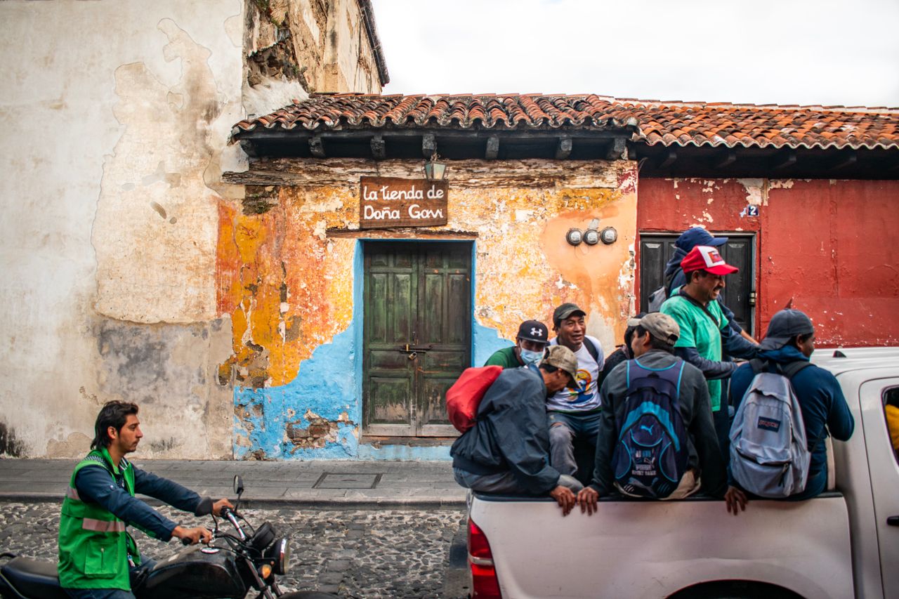Colorful street scene with locals and rustic architecture in Antigua, Guatemala.
