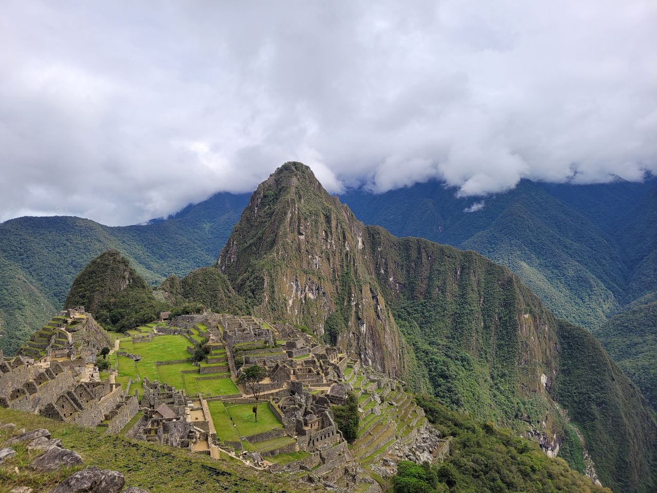 Stunning aerial view of the historic Machu Picchu in the Andes mountains, showcasing its ancient architecture and lush surroundings.